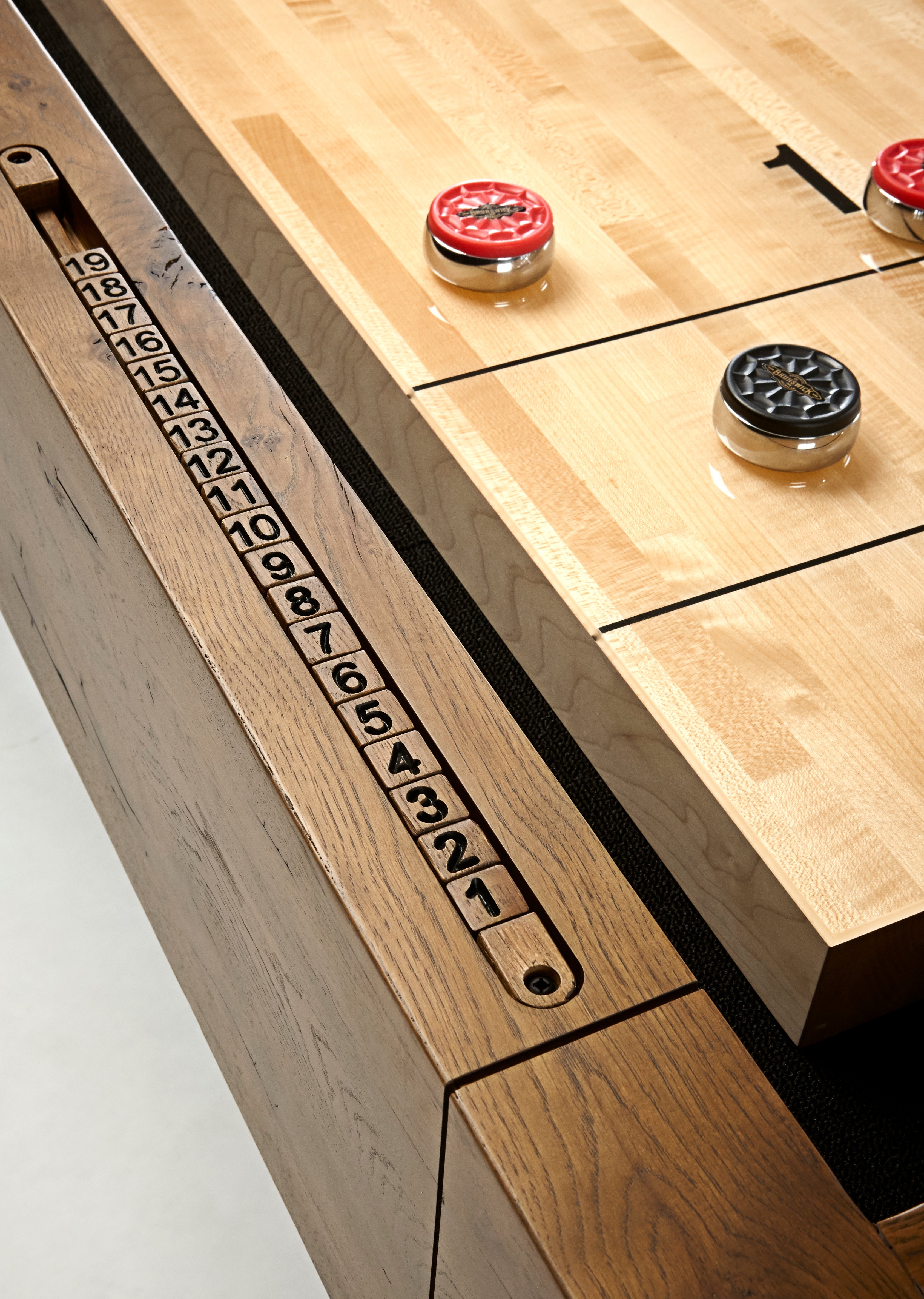 Brunswick Billiards Parsons 12' Shuffleboard Table with red/black pucks and wooden scoring track.