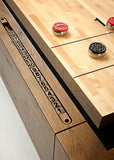 Brunswick Billiards Parsons 12' Shuffleboard Table with red/black pucks and wooden scoring track.