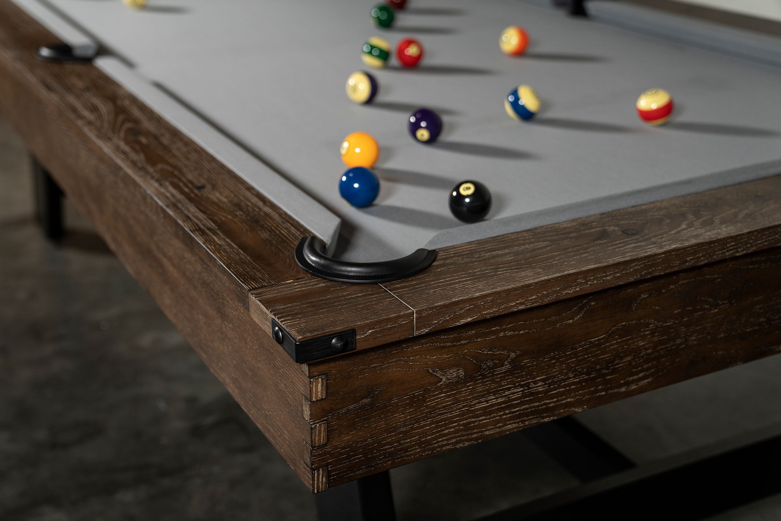 Close-up of Nixon Billiards Hunter 7' Slate Pool Table in Brushed Walnut with balls on grey felt.