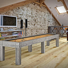 A Brunswick Billiards Sanibel 12' Rustic Grey table in a loft with brick walls and wood floors.