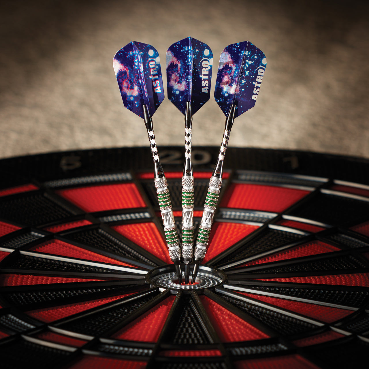 Three Viper Astro Tungsten Soft Tip Darts with green rings hit the bullseye of a dartboard.