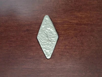 A silver rhombus rests on an American Heritage Billiards Abbey 8' Slate Pool Table in espresso.