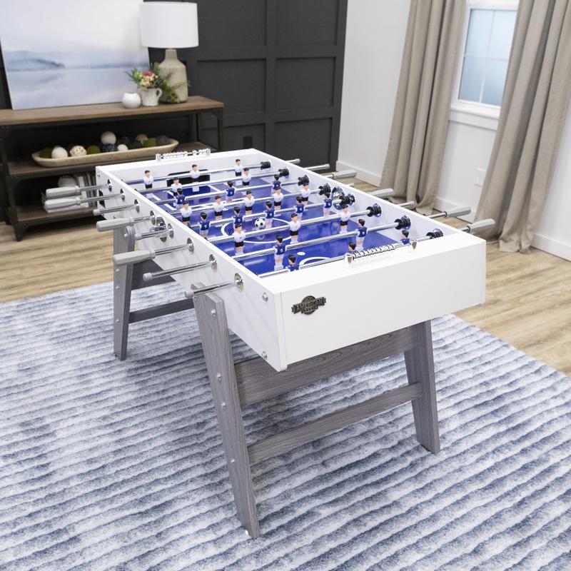American Legend Manhattan Foosball Table with blue field on striped rug in a modern living room.