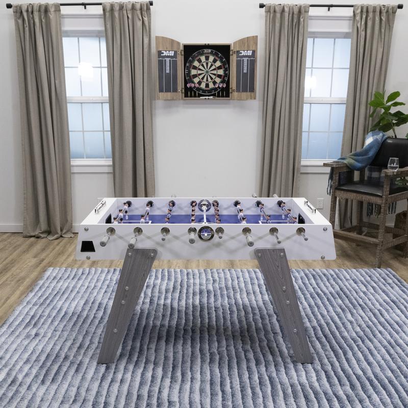 American Legend Manhattan Foosball Table on a rug, with a dartboard mounted on the wall.
