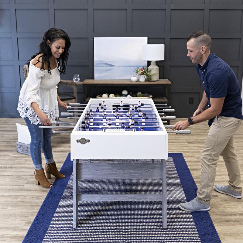 A man and woman playing on an American Legend Manhattan Foosball Table.