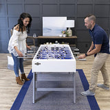 A man and woman playing on an American Legend Manhattan Foosball Table.