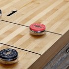 Close-up of Brunswick Billiards Canton 14' Shuffleboard Table in Black Forest with pucks.