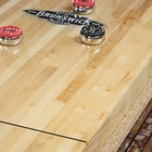 Brunswick Billiards Canton 14' Shuffleboard Table in Black Forest with red and black pucks.