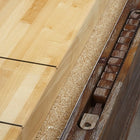 Close-up of Brunswick Billiards Canton 14' Shuffleboard Table in Black Forest with pucks.