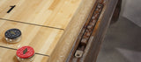 Close-up of Brunswick Billiards Canton 14' Shuffleboard Table in Black Forest with pucks.