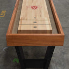 The Venture Monaco 18' Shuffleboard Table of solid white oak sits on a concrete floor.
