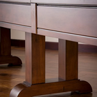 Close-up of an American Heritage Billiards Milan 14' Shuffleboard Table leg on hardwood floor.