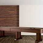 The American Heritage Billiards Milan 14' Shuffleboard Table in Navajo stands on wood flooring.