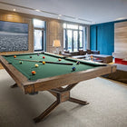 A Brunswick Billiards Dameron 8' Slate Pool Table in Nutmeg in a modern room with large windows.