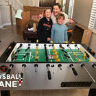 A woman and two kids stand by a Tornado T-3000 Foosball Table (Silver Coin) in a living room.
