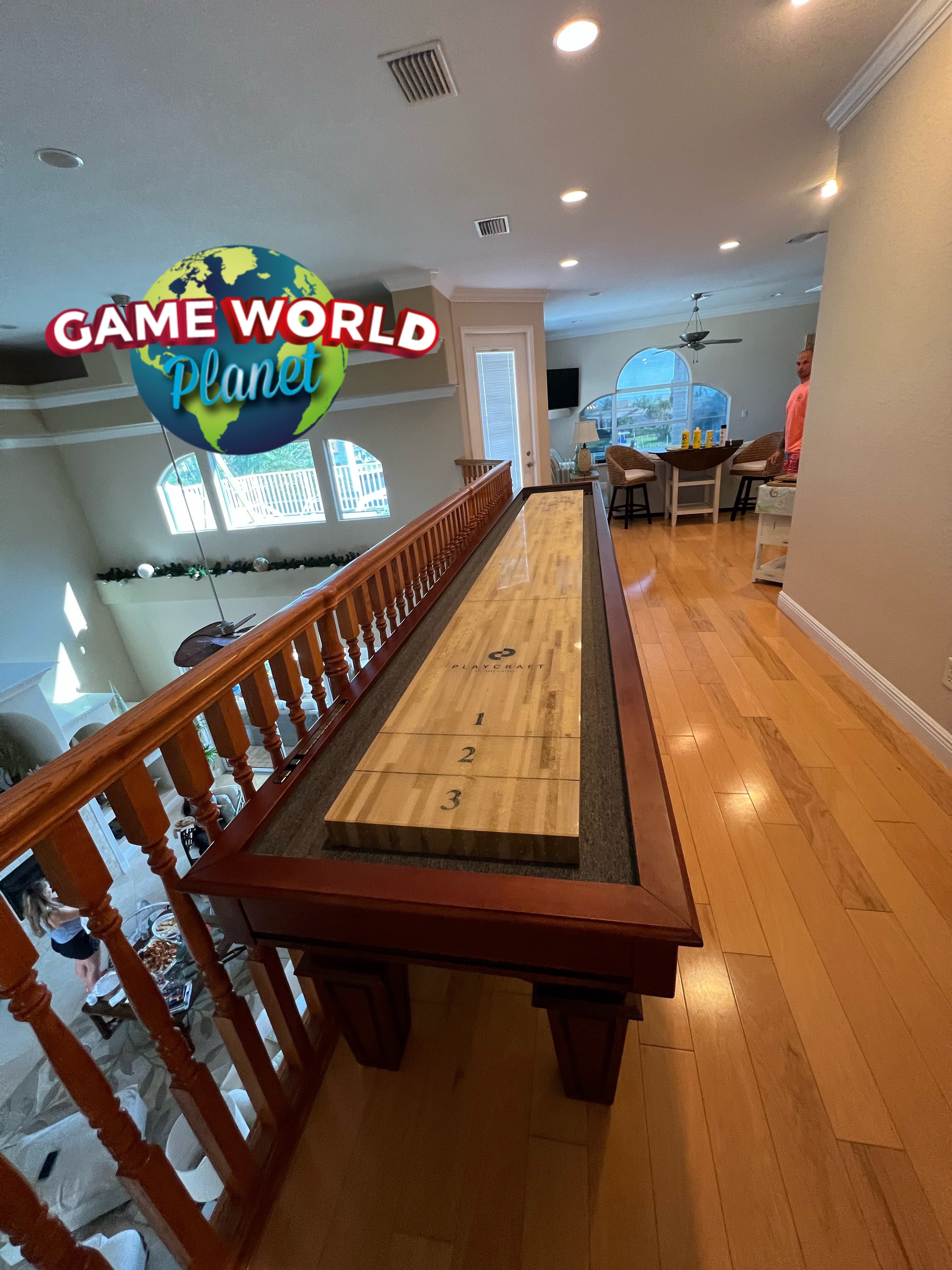 Playcraft St. Lawrence 16' Pro-Style Shuffleboard Table in Chestnut enhances any hallway setting.
