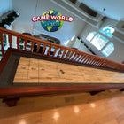 Playcraft St. Lawrence 16' Shuffleboard Table in Chestnut beneath Game World Planet sign.