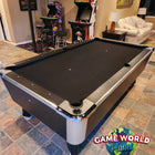 A Great American Legacy Home pool table sits in a game room with two arcade machines behind it.