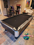 A Great American Legacy Home pool table sits in a game room with two arcade machines behind it.