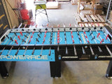 Warrior 8 Players Foosball Table with split bearing in a warehouse setting.
