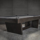Nixon KAI 7' Slate Pool Table in Waxed Brown by Nixon Billiards shown on a concrete floor.