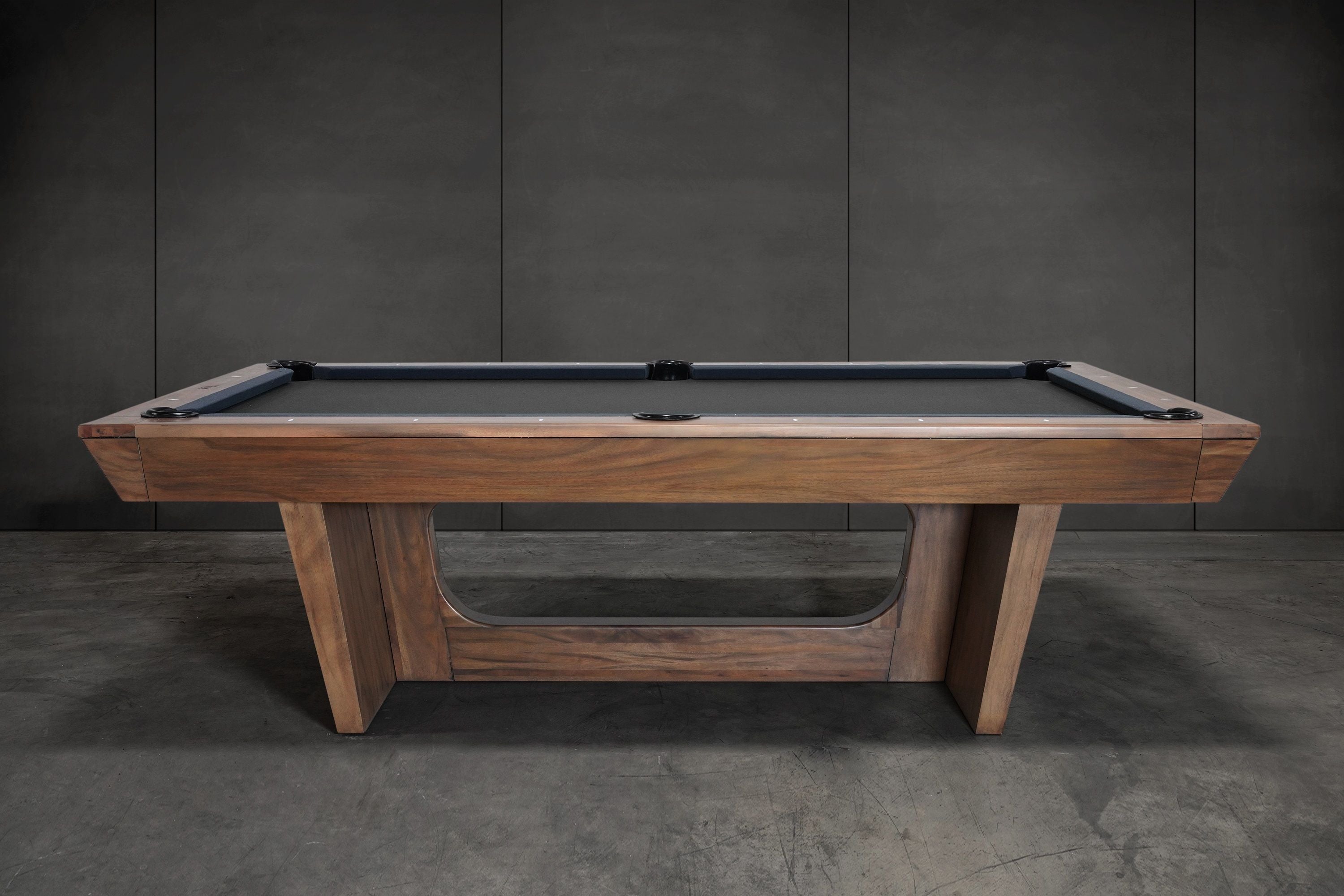 Nixon KAI 8' Slate Pool Table in Walnut by Nixon Billiards, shown with dark felt and gray wall.