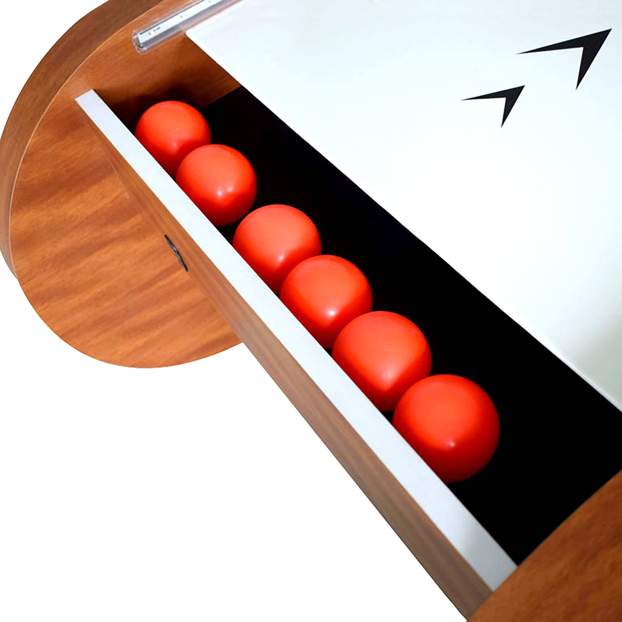 Six red balls line up in the Hathaway Boardwalk 8-ft Roll Hop and Score Arcade Game Table drawer.