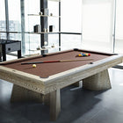 A modern room with a Brunswick Billiards Sagrada 8' Slate Pool Table in Sandwashed and cue stick.