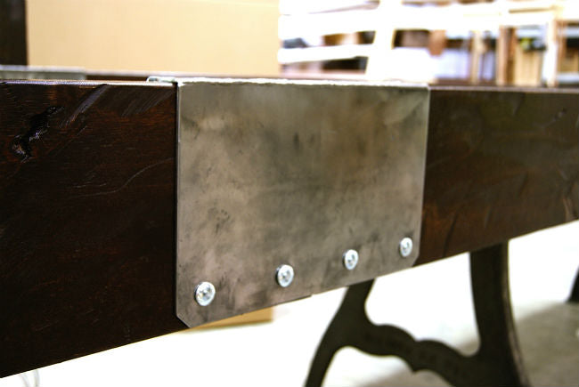 A metal plate with four bolts is fixed to the Venture Williamsburg 12' Shuffleboard Table.