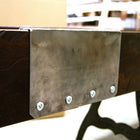 A metal plate with four bolts is fixed to the Venture Williamsburg 12' Shuffleboard Table.