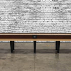 Venture Classic 14' Shuffleboard Table with black legs against a white brick wall background.